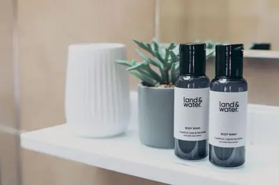 two bottles of liquids sitting on a bathroom shelf at North Lakes - The Fold Holiday Cottage in Penrith