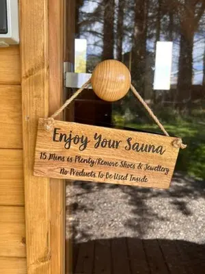 a wooden sign on the door of a house at Bracken Barns Glamping & Massage in Minishant
