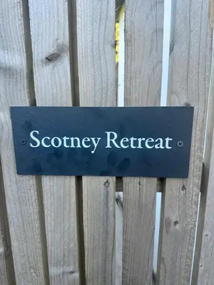 a sign on a wooden fence with the word security retreat at Scotney Retreat in Moffat