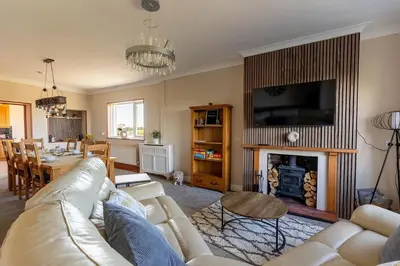 a living room with a couch and a fire place at Spacious 4-Bed Lake District Getaway for Groups in Mealsgate