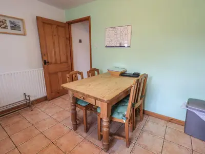 a wooden table and chairs in a room at Capella Cottage in Keswick