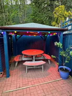 a picnic table and bench under a gazebo at Tigh-Na-Mara Hotel in Sandhead