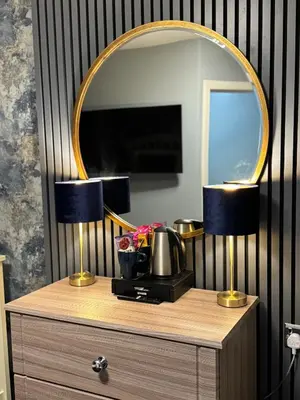 a table with two lamps and a mirror on it at Tigh-Na-Mara Hotel in Sandhead