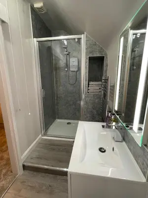 a bathroom with a shower and a white sink at Tigh-Na-Mara Hotel in Sandhead