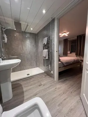 a bathroom with a tub and a sink and a bed at Tigh-Na-Mara Hotel in Sandhead