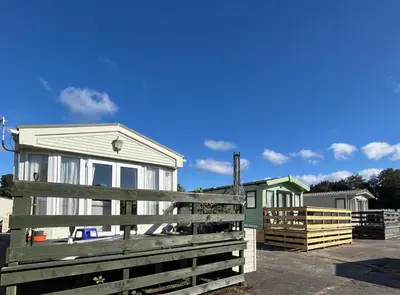 a house with a wooden fence in front of it at Creebridge Caravan Park in Newton Stewart