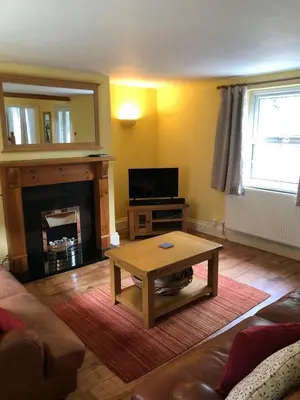 a living room with a coffee table and a fireplace at High House Cottage - A traditional home from home in St Bees