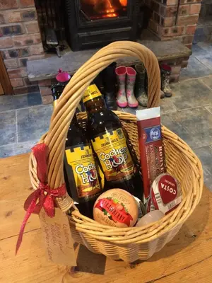 a basket of beer and other items on a table at High House Cottage - A traditional home from home in St Bees