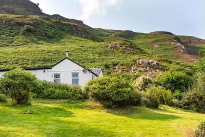 a white house in front of a grassy hill at Catbells Sunrise Cottage Borrowdale Lake District in Keswick
