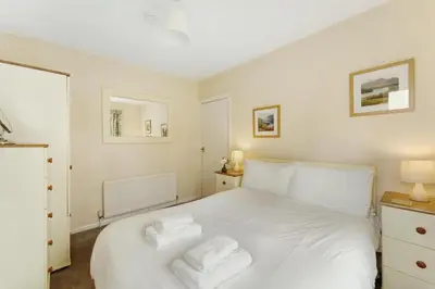 a bedroom with a white bed with two towels on it at Burnmoor in Keswick