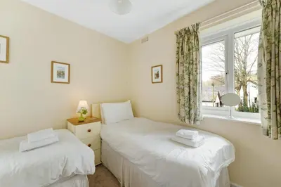 two twin beds in a room with a window at Burnmoor in Keswick