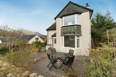 a table and chairs in front of a house at Burnmoor in Keswick
