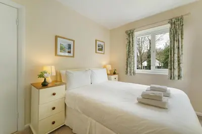 a bedroom with a white bed and a window at Burnmoor in Keswick