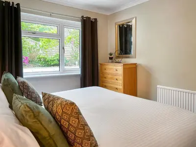 a bedroom with a bed and a window and a dresser at Autumn Leaves in Keswick