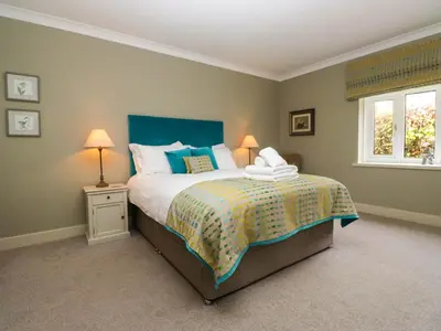 a bedroom with a bed and two lamps and a window at Osprey Cottage in Ambleside
