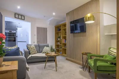 a living room with a couch and a tv on a wall at Moss Crag in Penrith
