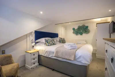 a bedroom with a large bed with a blue headboard at Moss Crag in Penrith