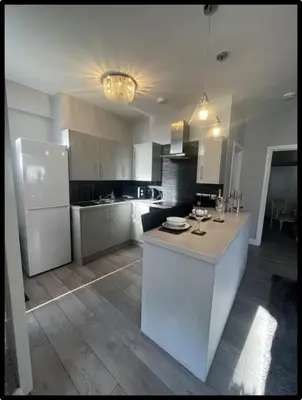 a kitchen with a white counter and a refrigerator at Coastal Cwtch in Moffat