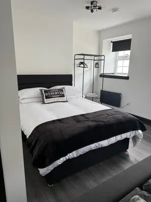 a black and white bedroom with a large bed at GlasVenn Cottages in Irvine
