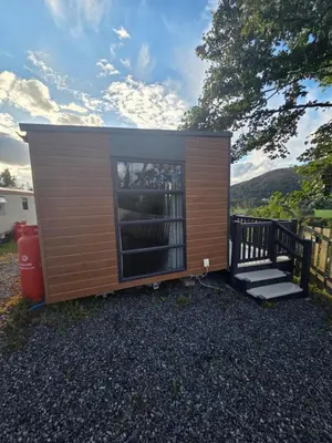 a tiny house with a large window and stairs at The View in Ballantrae