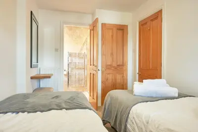 a white room with two beds and a door at Manesty House - Rooms only - no kitchen-living in Keswick