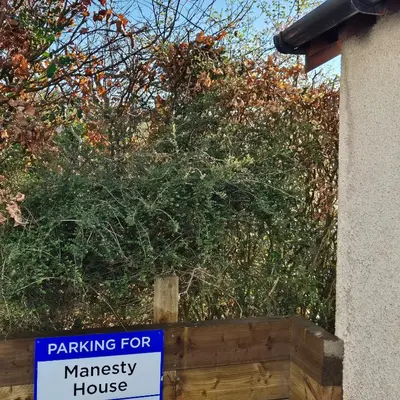 a sign for ministerial house in front of a bush at Manesty House - Rooms only - no kitchen-living in Keswick