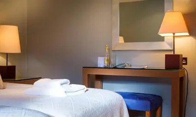 a hotel room with a bed and a vanity with a mirror at Robinson in Keswick
