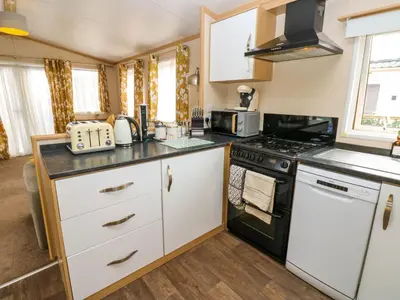 a kitchen with white cabinets and a stove top oven at Cates Cozy Cabin in Carlisle