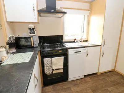 a small kitchen with a stove and a sink at Cates Cozy Cabin in Carlisle