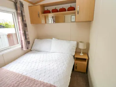 a small bedroom with a bed and a window at Cates Cozy Cabin in Carlisle