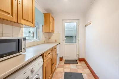 a kitchen with wooden cabinets and a microwave at 2 Bed in Allonby oc-i30743 in Allonby