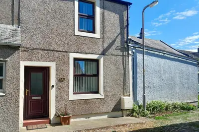 a brick house with a door and a street light at 2 Bed in Allonby oc-i30743 in Allonby