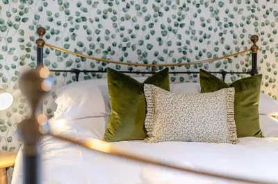 a bed with white sheets and green pillows at 3 Bed in Caldbeck oc-h30704 in Caldbeck