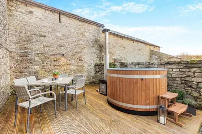 a hot tub on a deck with a table and chairs at 3 Bed in Caldbeck oc-h30704 in Caldbeck