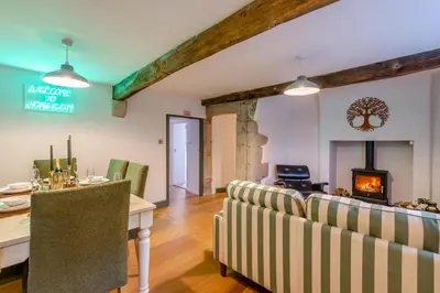 a living room with a table and chairs and a fireplace at 3 Bed in Caldbeck oc-h30704 in Caldbeck