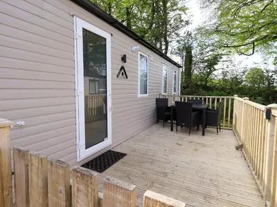 a deck with a table and chairs on a house at Seren in Cockermouth