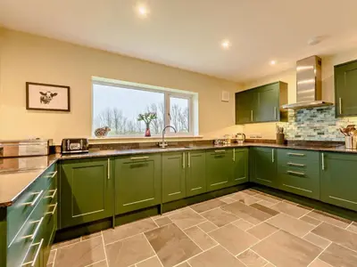 a green kitchen with green cabinets and a window at 3 Bed in Keswick oc-93589 in Threlkeld