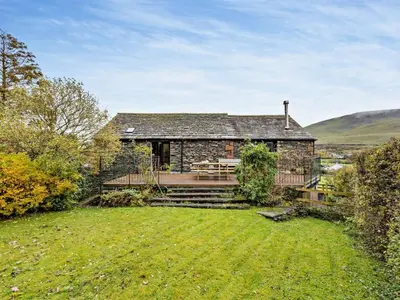 a stone house with a lawn in front of it at 3 Bed in Keswick oc-93590 in Threlkeld