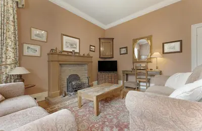 a living room with a fireplace and a tv at Poet's View Cottage in Grasmere
