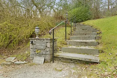 a set of stairs leading up a hill with a sign at Poet's View Cottage in Grasmere