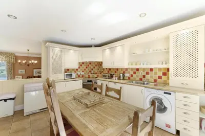 a kitchen with a table and a washing machine at Poet's View Cottage in Grasmere