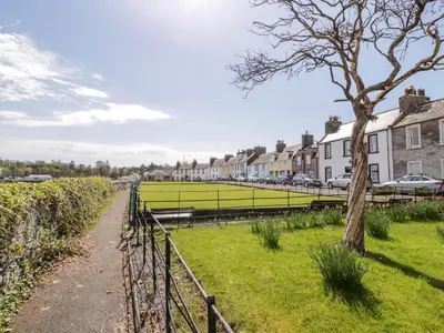 a field of grass next to houses and a fence at 2Loos in Newton Stewart