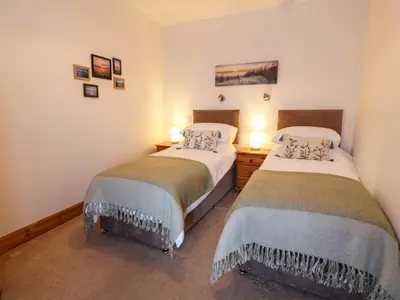 two twin beds in a room with two lamps at 2Loos in Newton Stewart