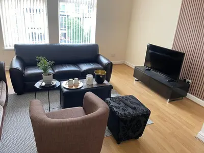 a living room with a couch and a tv at New Stylish Large 1-Bed Apartment - Close to Old Trafford & More in Moffat