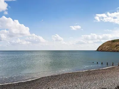 a beach with a rocky shoreline and the ocean at The St Bees Knees in St Bees