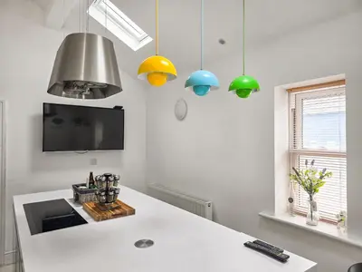 a kitchen with a white counter and some lights at The St Bees Knees in St Bees