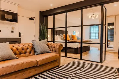 a living room with a couch and a bedroom at Luxury Georgian Aparthotel by Hauss Ayr - 5mins to Beach, Town Centre! in Ayr