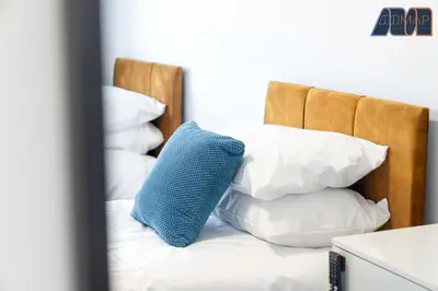 a blue pillow sitting on a bed with white pillows at 3BR Home in Kilmarnock Sleeps 6 in Kilmarnock
