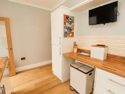 a kitchen with a desk and a tv on the wall at Grace House in Wigton