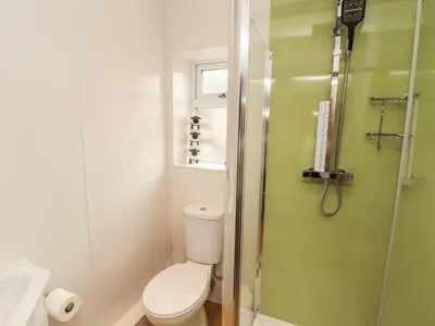 a bathroom with a toilet and a glass shower at Grace House in Wigton